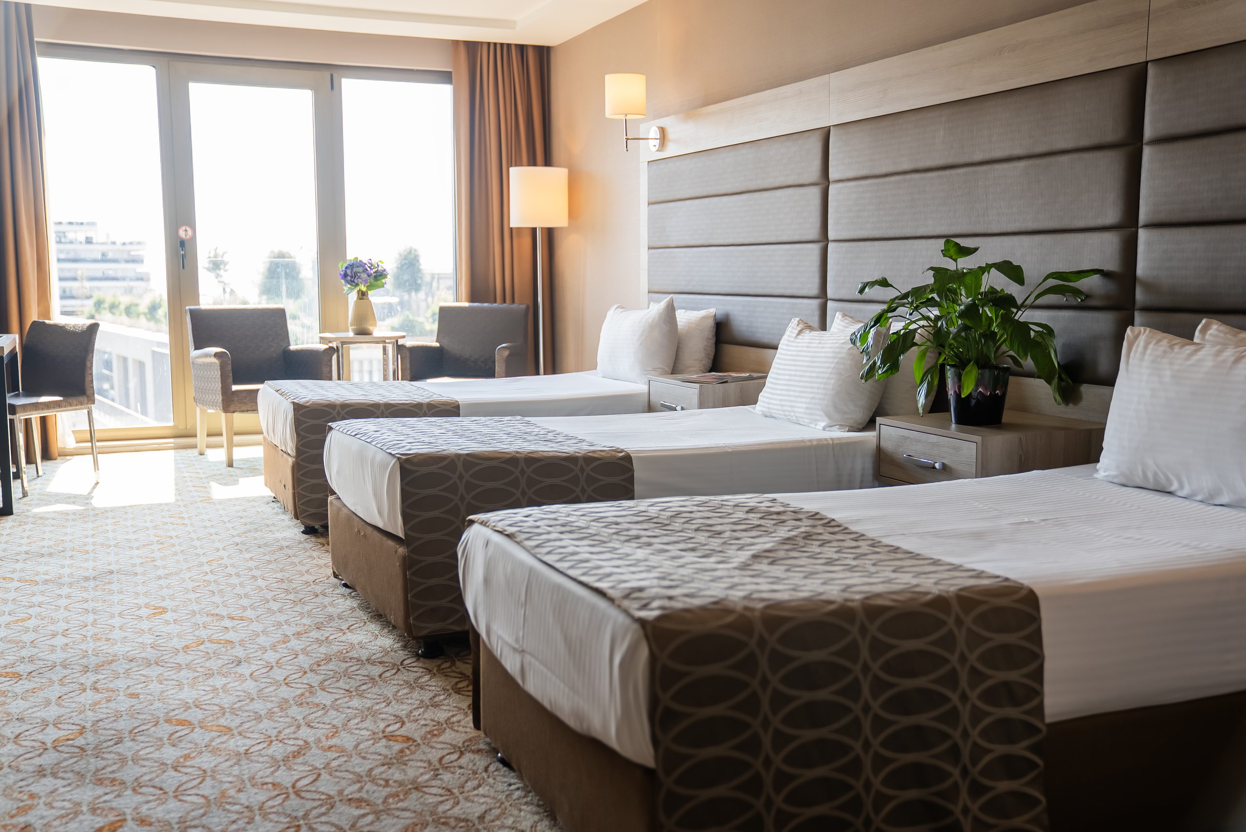 Superior triple room: three single beds and a seating corner by the window