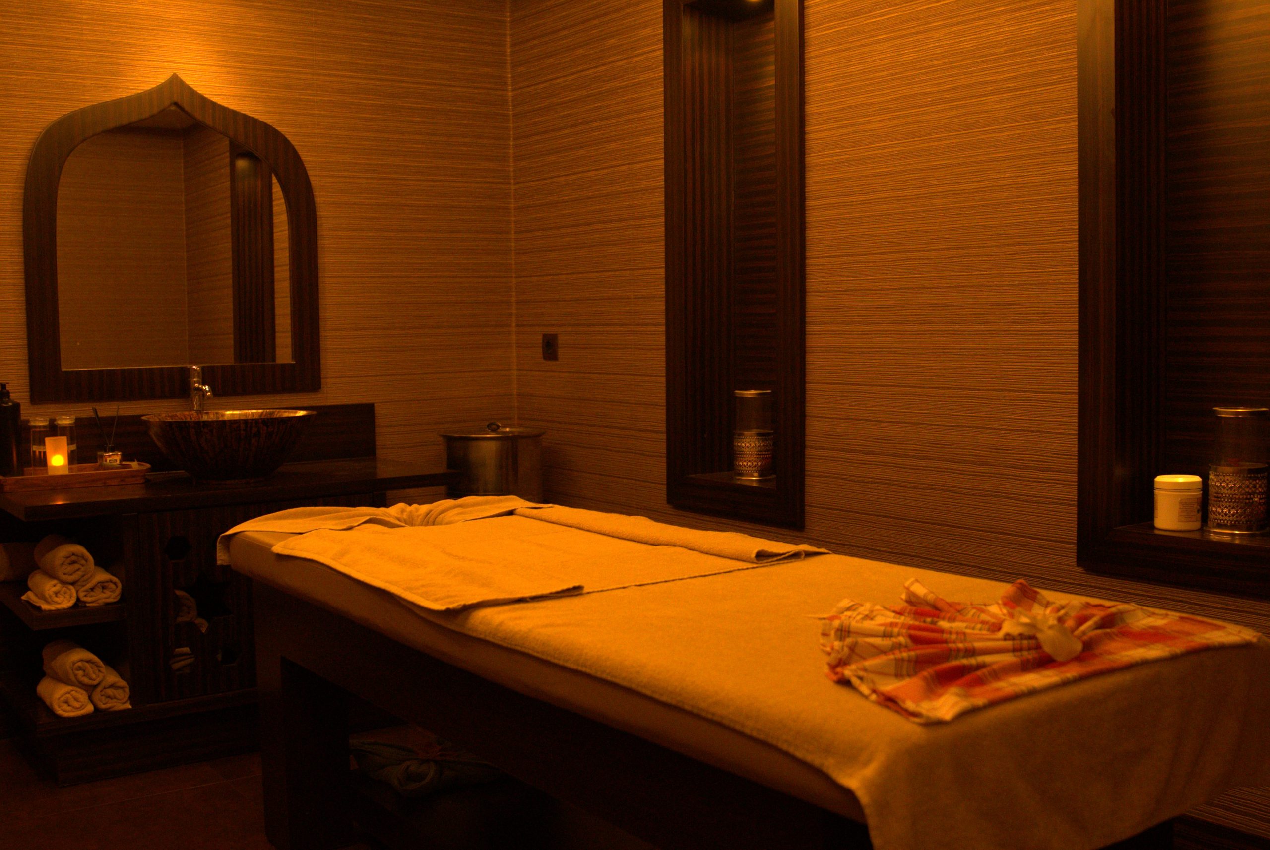 Massage room: massage bed, arched mirror and warm light